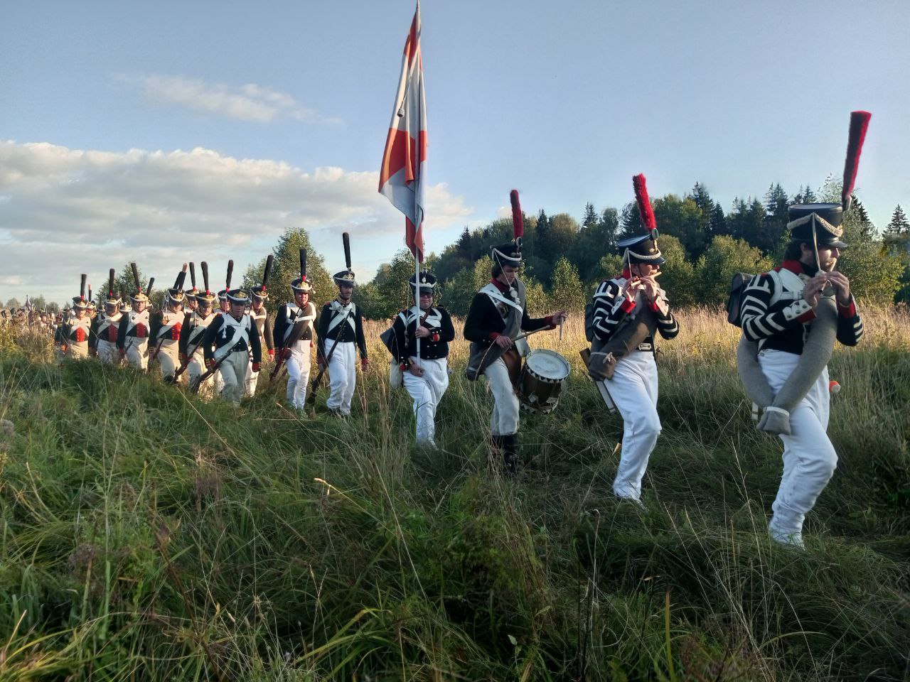 Колонна пехоты в мундирах 1812 года со знаменем на марше к Бородинскому полю